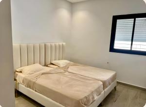 un lit dans une chambre blanche avec une fenêtre dans l'établissement Villa Bianca, à Sidi Jedidi 29 autres photos