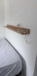 ein Regal an einer Wand neben einem Bett in der Unterkunft Studio cv 4p, parking privée cosy design in La Grande-Motte