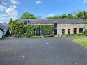 an old brick building with ivy growing on it at The Barn, Walworth Demesne in Ballykelly