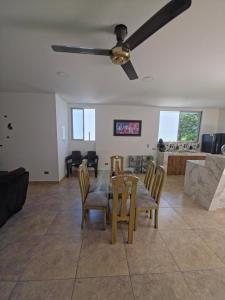 a living room with a table and chairs and a ceiling fan at Quinta VillaAurora in Carmen de Apicalá