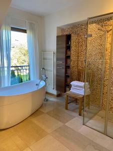 a bathroom with a tub and a glass shower at KITZHORN EMOTIONS near skilift by Belle-Stay in Jochberg