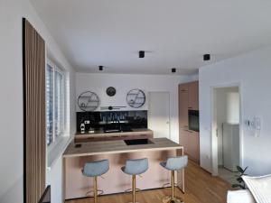 a kitchen with white walls and blue stools at Apartments Ana in Maribor