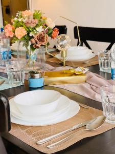 une table avec des assiettes blanches et un vase de fleurs dans l'établissement Vantage Point 101, à Olten