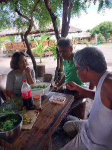 a group of people sitting at a picnic table at Beachfront Aircon Modern Bahay Kubo for 10 pax in Caba