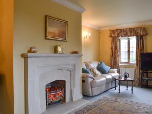 a living room with a fireplace and a couch at The Wain House in Chirk