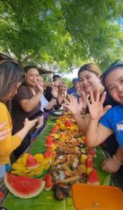 a long table of food with people standing around it at Beachfront Aircon Modern Bahay Kubo for 10 pax in Caba