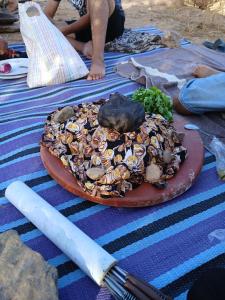 una pizza con champiñones en un plato con un cuchillo en Agoudim Nikhartan, en Tinerhir