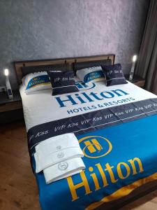 un lit avec un signe Hilton dessus dans l'établissement Luxury apartment in building K55 with free garage, à Varna