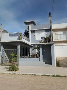 una casa blanca con una puerta y una valla en Sobrado Cinza com Hidromassagem, en São Lourenço do Sul