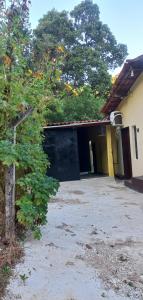 Un edificio con una puerta negra y un árbol. en A Pousada Marcolino, en Baturité 35 fotos más