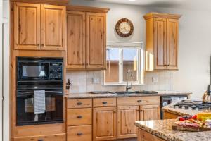 a kitchen with wooden cabinets and a sink at 1144 Equinox in Colorado Springs +40 photos