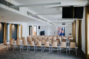 ein Konferenzraum mit Stühlen und einer Projektionsleinwand in der Unterkunft Heritage Hotel Knopp in Novska