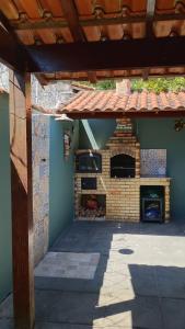 an outdoor patio with a brick oven in a house at Casa aconchegante na praia in Cabo Frio