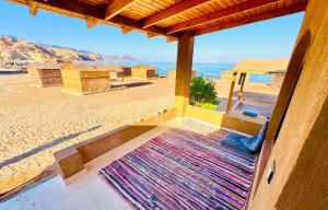 eine Veranda mit Blick auf den Strand in der Unterkunft Luna Camp in Nuweiba