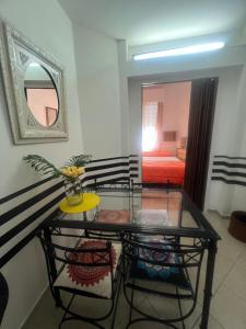 a room with a glass table and a bedroom at Corazón obelisco 4 in Buenos Aires