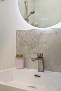 ein Waschbecken mit einem Wasserhahn und einer Kerze in der Unterkunft Soft Wood - Duplex - Historique in Reims + 14 Fotos