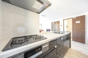 a kitchen with a stove and a sink at Skytree House Oshiage New 3-story Villa, 2 Showers, 2 Toilets, 4 Rooms, 3 min walk to Oshiage Station in Tokyo +34 photos