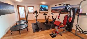 ein Fitnessstudio mit mehreren Trainingsgeräten in einem Raum in der Unterkunft Ferienwohnungen Hipp - Bergblick und Wellness in Top Lage in Halblech