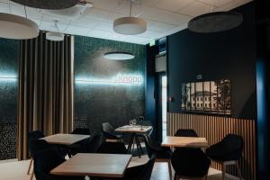 ein Restaurant mit Tischen und Stühlen und ein Schild an der Wand in der Unterkunft Heritage Hotel Knopp in Novska