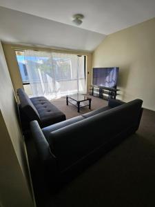a living room with a couch and a table at Chriatcurrch Best Home in Christchurch