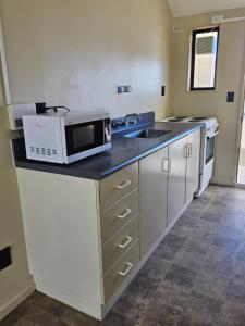 a kitchen with a microwave and a sink at Chriatcurrch Best Home in Christchurch