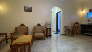 a living room filled with wooden chairs and a tv at Tibs mountain view in Al Aqālitah