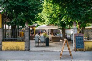 un panneau devant un restaurant avec des personnes assises à table dans l'établissement Hotel Katrca, à Ljubljana