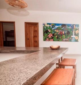 a kitchen with a counter and a painting on the wall at Nica Nest 3Br Eco Home Escamequita, NI in San Juan del Sur