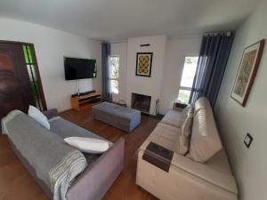 アチバイアにあるCasa Varanda Por do Sol - Piscina Climatizada - Dentro da Cidadeのリビングルーム(ソファ2台、テレビ付)
