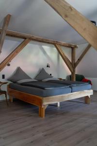 a bed in a room with a wooden frame at Eiche - Ferienwohnung in Dötlingen mit Waldblick in Dötlingen