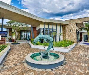 a statue in a fountain in front of a building at 832 Villa in Ballito