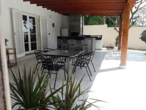 アチバイアにあるCasa Varanda Por do Sol - Piscina Climatizada - Dentro da Cidadeのパティオ(テーブル、椅子付)