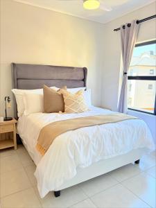 a bed with white sheets and pillows in a bedroom at 832 Villa in Ballito +18 photos