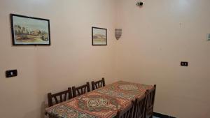 uma sala de jantar com uma mesa e uma cama com uma mesa em West Bank Guest House em Luxor