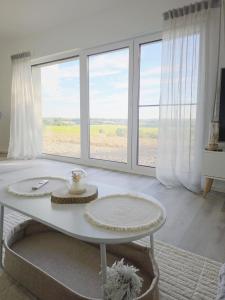 a living room with a table and large windows at Panorama trifft Gemütlichkeit in Nümbrecht
