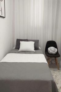 a bed and a chair in a bedroom at Cozy Haven Downtown Abu Dhabi in Abu Dhabi