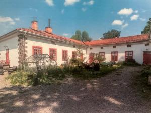 a large white building with red windows at 2 rok i Söderfors wärdshus in Söderfors