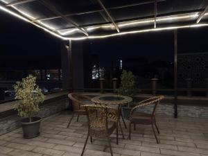 a table and chairs on a balcony at night at Hotel Taht in Tashkent +10 photos