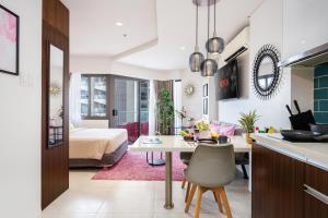 a kitchen and living room with a table and a bedroom at Dominiks pink dream Studio Balcony Ocean View Balcony Fast-Wifi at Tambuli Resort High Floor in Maribago