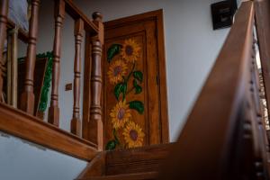 a wooden staircase with flowers painted on the wooden door at Flora Birgi Taş Konak in Odemis