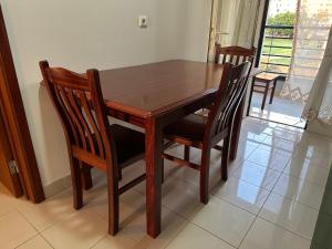 a wooden dining room table with four chairs at Forum Madeira near beach Formosa in Funchal +30 photos