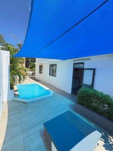 a swimming pool in the backyard of a house with a blue umbrella at Mimi villa in Port Louis