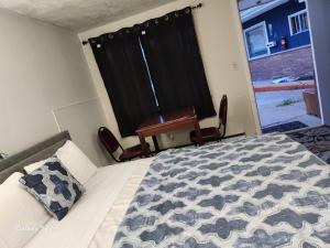 Un dormitorio con una cama y un escritorio y una ventana. en Town Inn Motel, en Standish