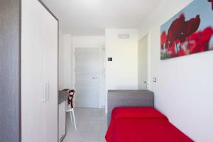 Schlafzimmer mit einem roten Bett und einem Schreibtisch in der Unterkunft Hotel La Maestra in Grottammare