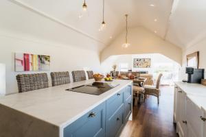 a kitchen with blue cabinets and a counter top at Stunning Abersoch Cottage by golf course & beach in Abersoch