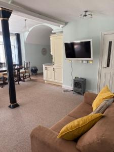 a living room with a couch and a flat screen tv at Bastian Gate Gosford Castle 