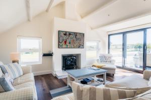 a living room with two couches and a fireplace at Stunning Abersoch Cottage by golf course & beach in Abersoch