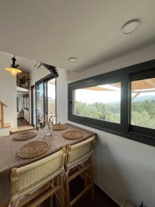a dining room with a table and a large window at Lagom Retreat - ASKOS in Agios Nikolaos