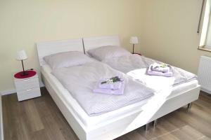 białe łóżko z dwoma ręcznikami na górze w obiekcie Ferienwohnung Lavendel w mieście Brüggen