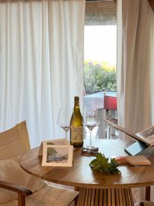 a bottle of wine and two glasses on a table at Casa Bougainvillea in Casa Azara